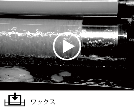 溶解したパラフィンワックスが入った受け皿の中で、ロールにそって紙を通過させて含浸していきます。